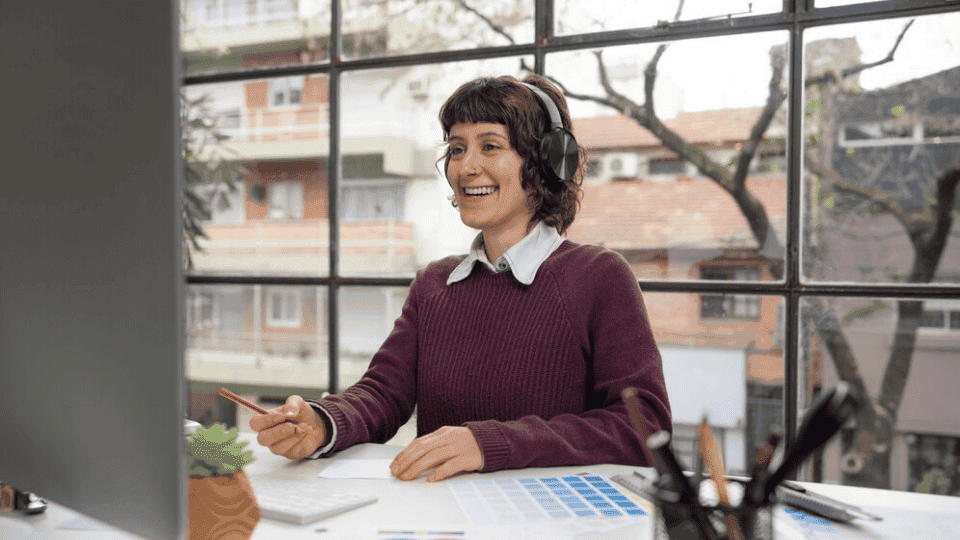 Smiling designer at a desk showcasing Company Profile Design.