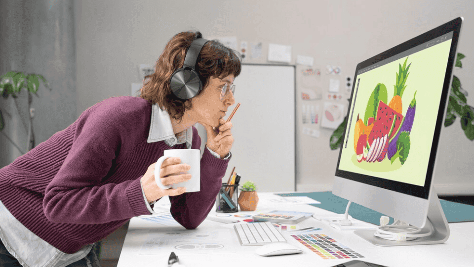 Designer creating fruit art on a computer, showcasing Business Card Design.